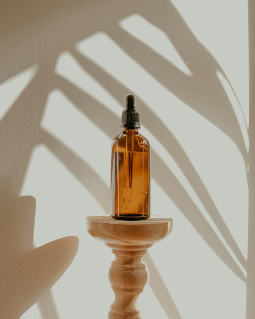 Amber serum bottle on a wooden pedestal